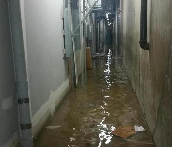 standing water in a narrow service corridor of a commercial building