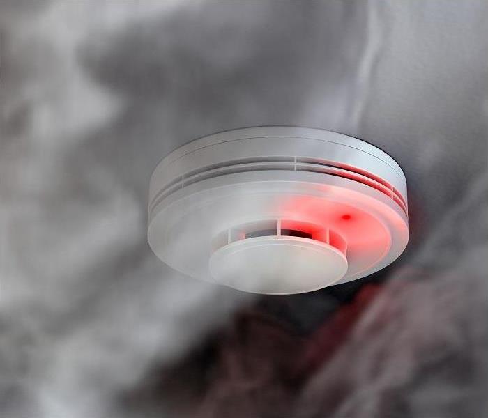 smoke filling a home and surrounding smoke detector